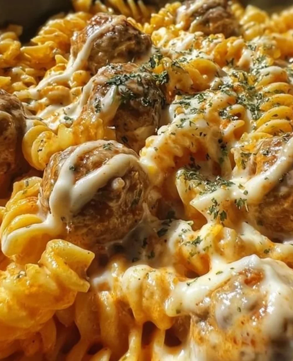 Delicious bowl of Bold Creamy Buffalo Ranch Meatball Pasta garnished with herbs.