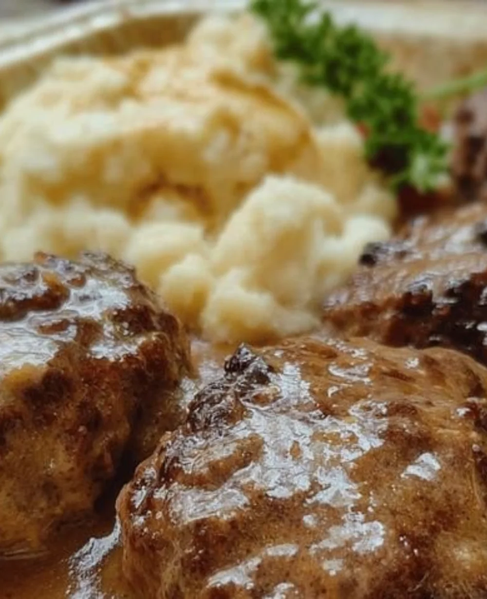 Amish Country Poor Man's Hamburger Steaks served with savory gravy over mashed potatoes