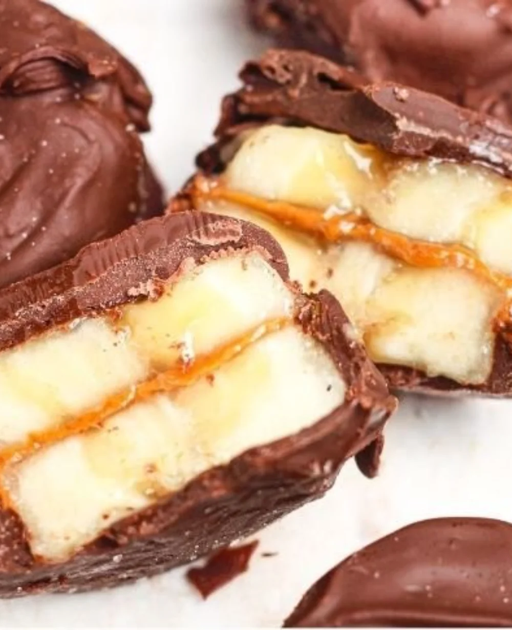 Chocolate dipped banana bites on a wooden platter