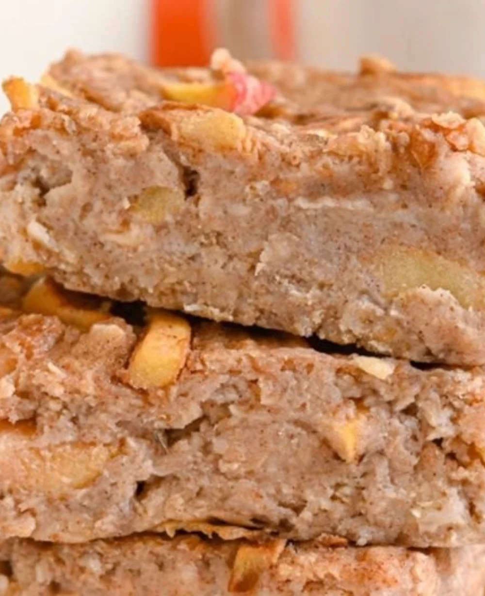 Delicious cinnamon oatmeal bars stacked on a wooden table.