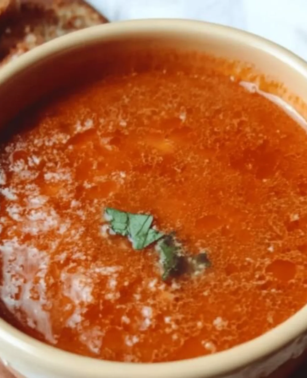 Bowl of Classic Vintage Tomato Soup garnished with basil and served warm.
