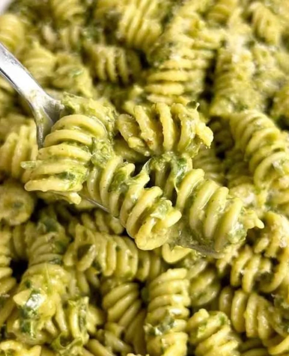 Creamy pesto pasta in a bowl with fresh basil and Parmesan cheese