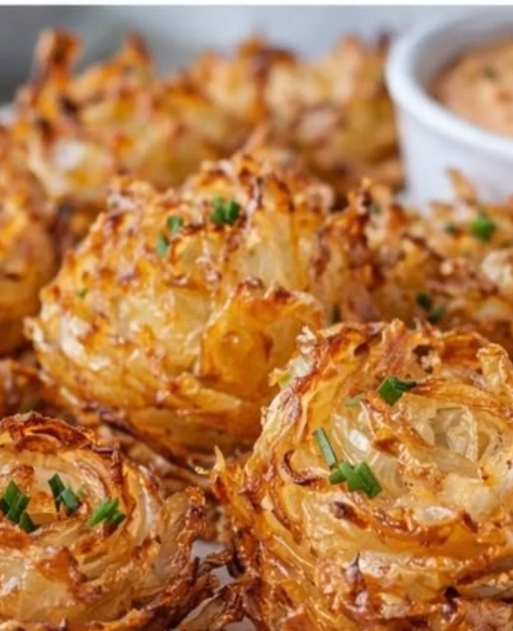 A plate of crispy mini blooming onions made in an air fryer, garnished and ready to enjoy.