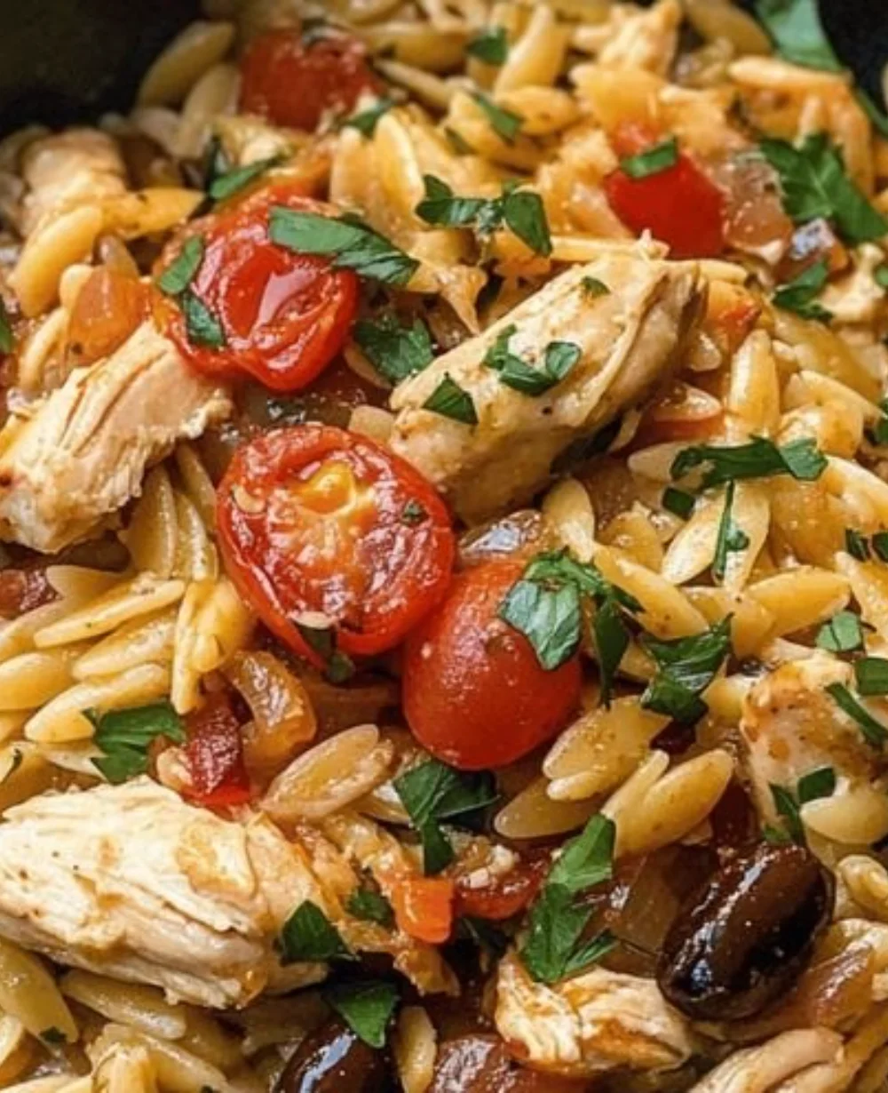 Delicious Mediterranean Chicken Orzo in a bowl garnished with fresh herbs.