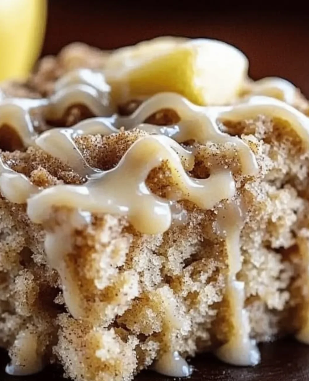 Irresistibly moist apple crumb cake with cinnamon drizzle on a rustic table.