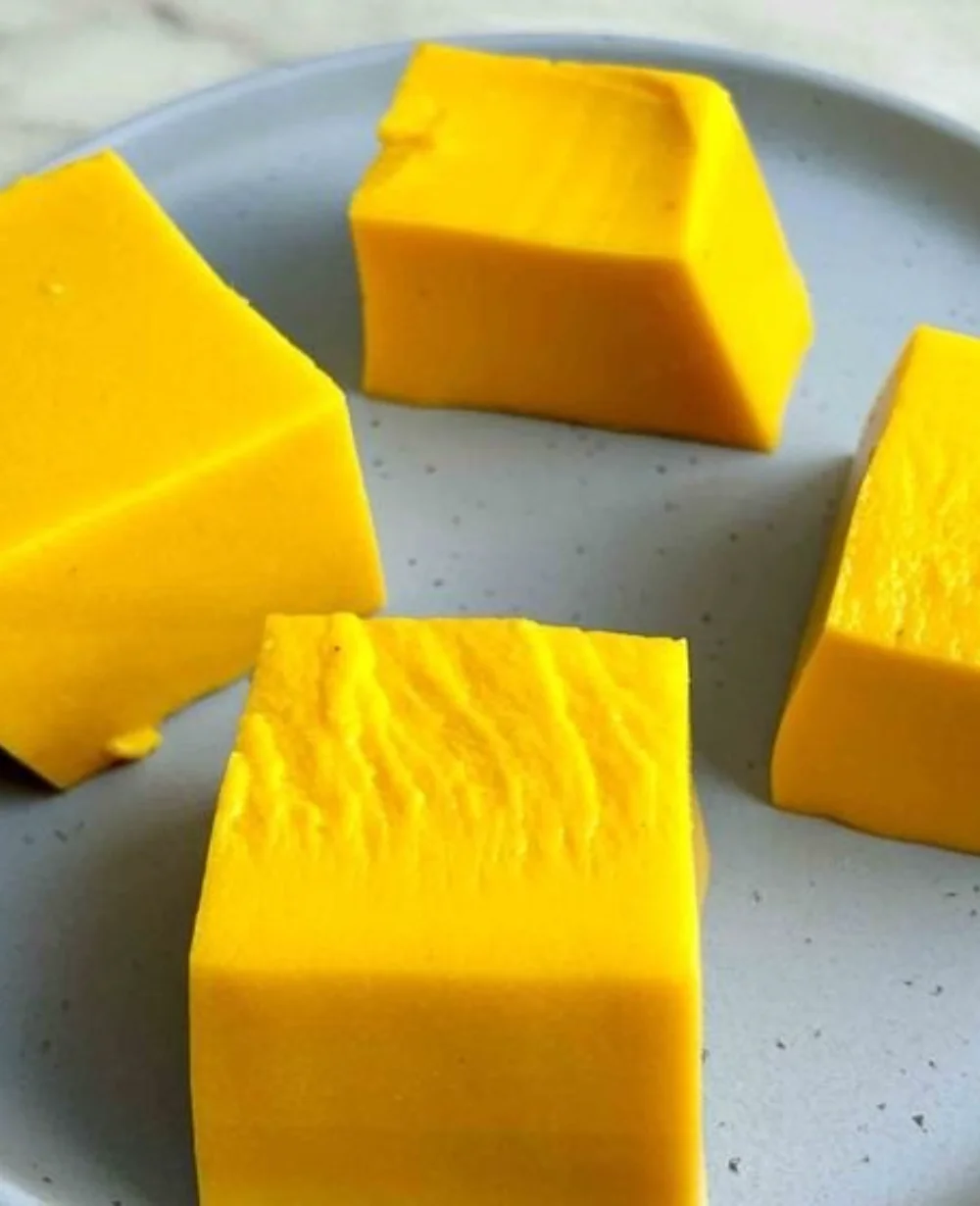 Delicious homemade mango pudding served in a bowl, garnished with fresh mango slices.