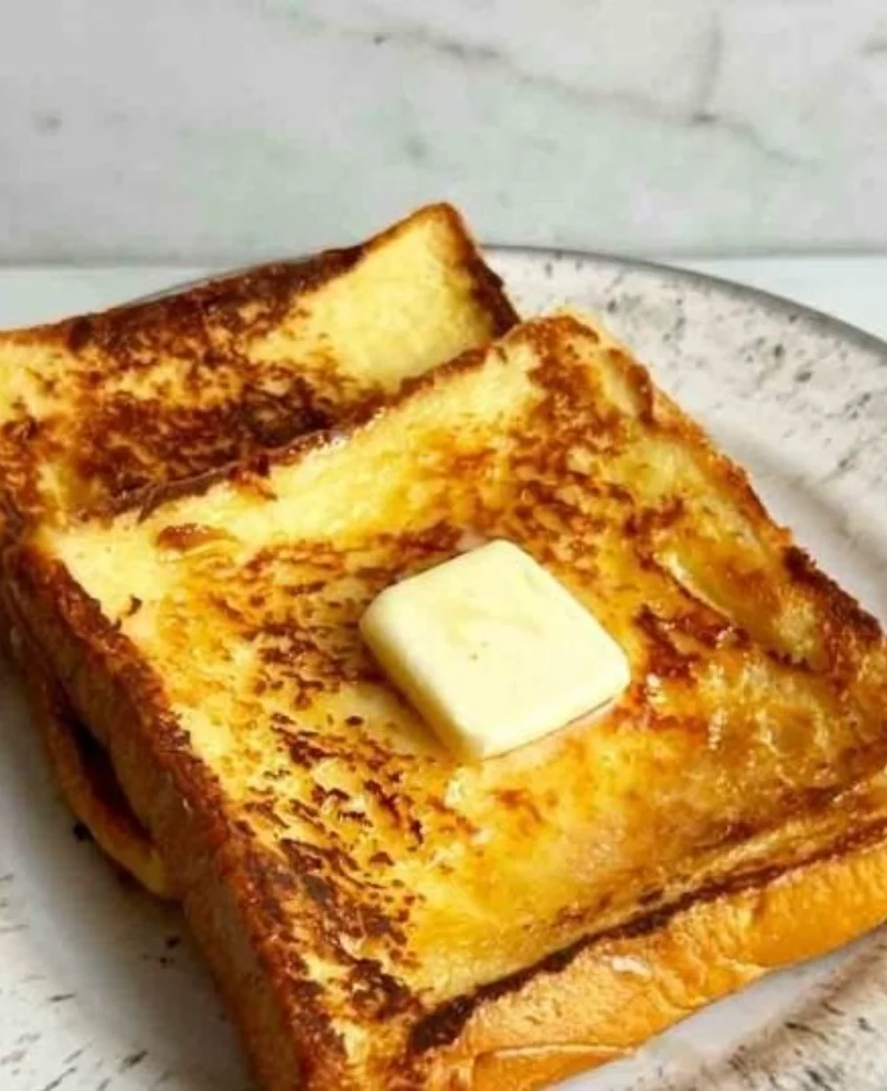 Delicious bowl of milk toast served with golden toast slices and a sprinkle of cinnamon.