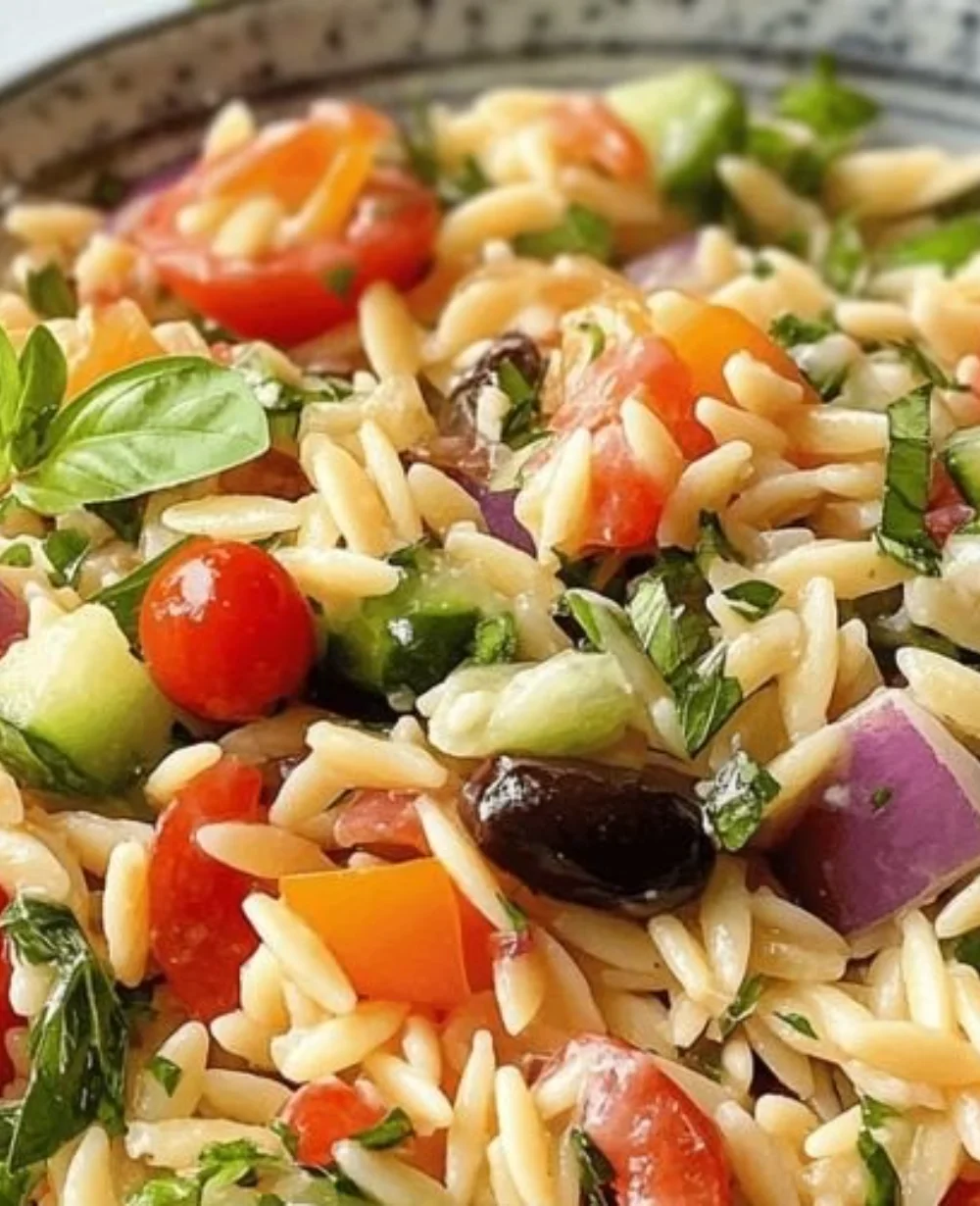 Colorful orzo salad with vegetables and dressing served in a bowl