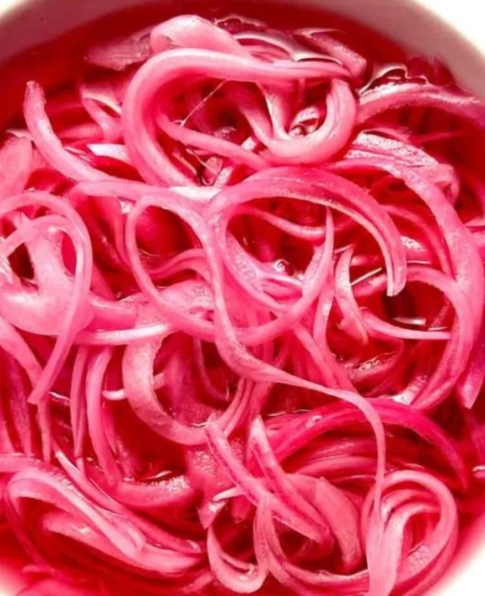 Bowl of pickled red onions, a tangy and flavorful condiment for various dishes