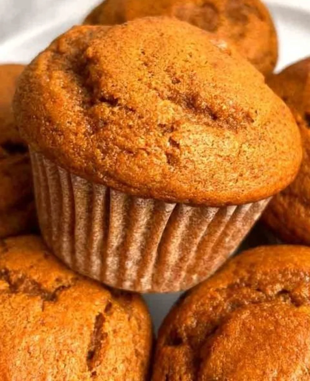 Freshly baked pumpkin muffins on a wooden table