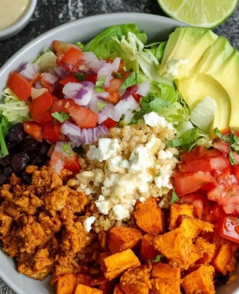 Colorful sweet potato taco bowls topped with fresh ingredients and herbs
