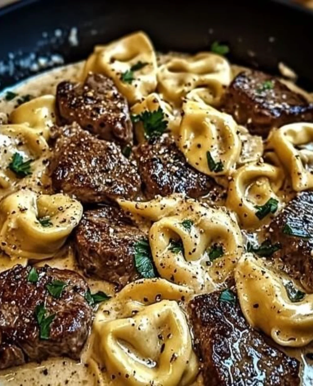 Delicious Cracked Garlic Steak Tortellini in creamy sauce, garnished and ready to serve.