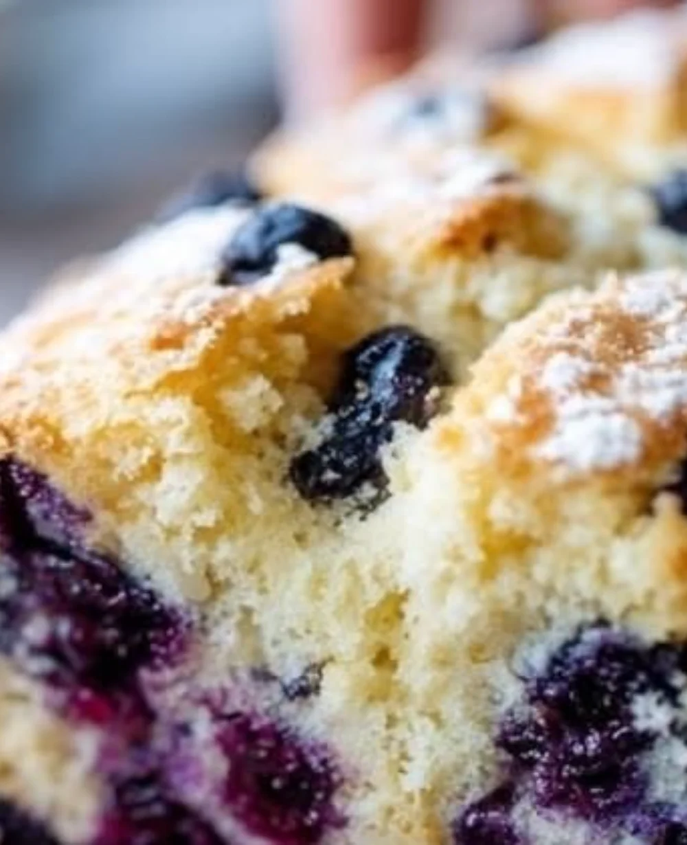 Freshly baked blueberry lemon sourdough loaf with golden crust and vibrant berries