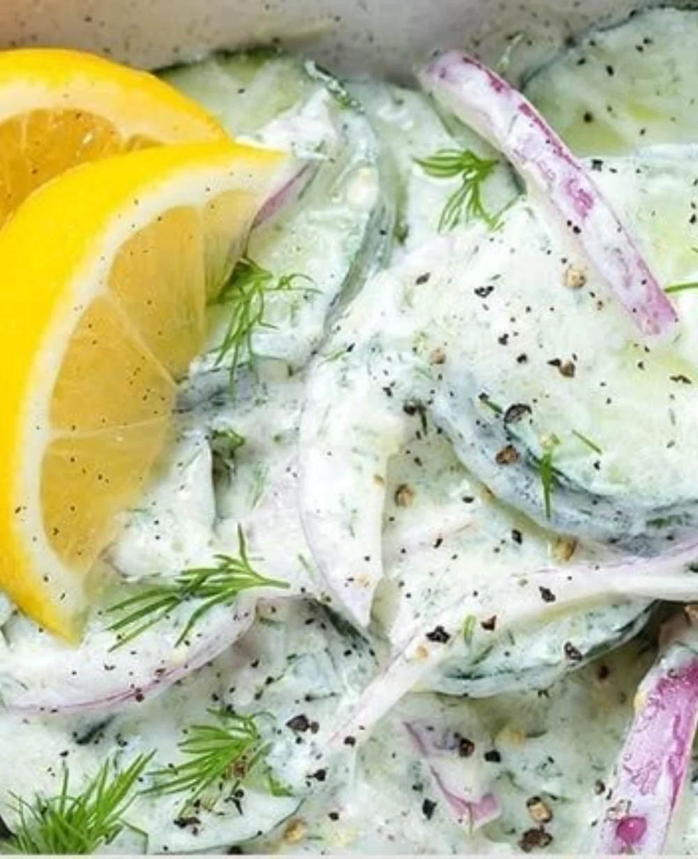 Cool and creamy tzatziki cucumber salad in a bowl, garnished with fresh herbs.