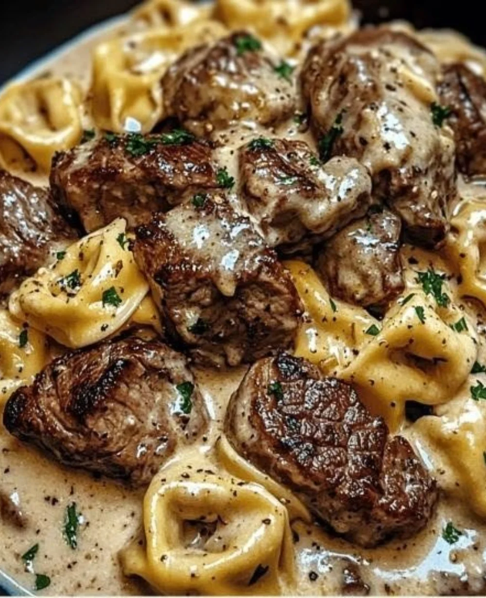 Creamy garlic steak tortellini served in a bowl with fresh herbs