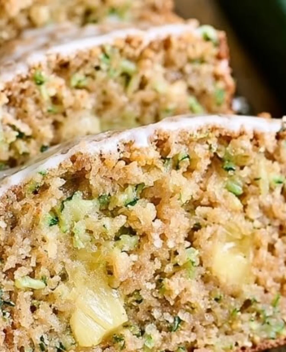 A delicious slice of homemade Pineapple Zucchini Bread on a wooden cutting board