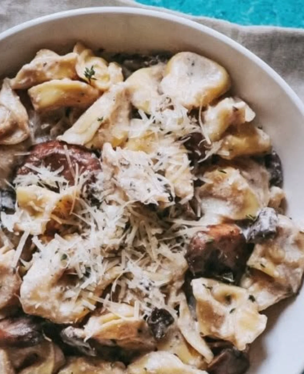 Creamy Tortellini Alfredo dish served in a bowl with parsley garnish.